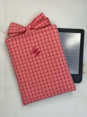 Funda de ebook Ágatha rosa de cuadros con cierre de lazo, junto a un ebook