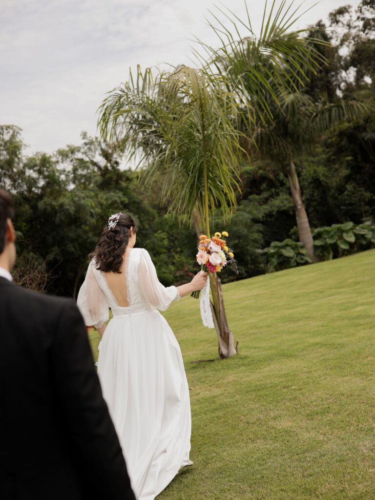 Novia caminando con el ramo por el jardín durante la boda de Ana y Pablo