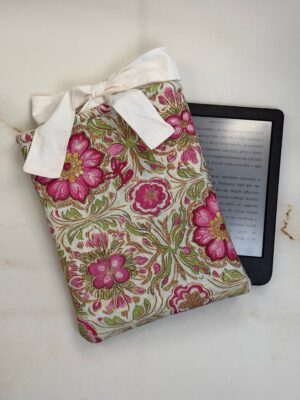 Funda de ebook Ágatha de flores rosas con cierre de lazo, junto a un ebook