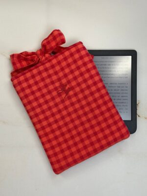 Funda de ebook Ágatha coral de vichy con cierre de lazo, junto a un ebook
