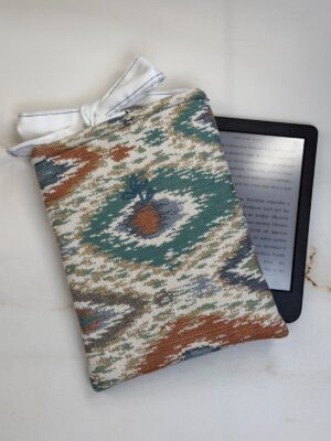 Funda de ebook Ágatha de estampado ikat con cierre de lazo, junto a un ebook