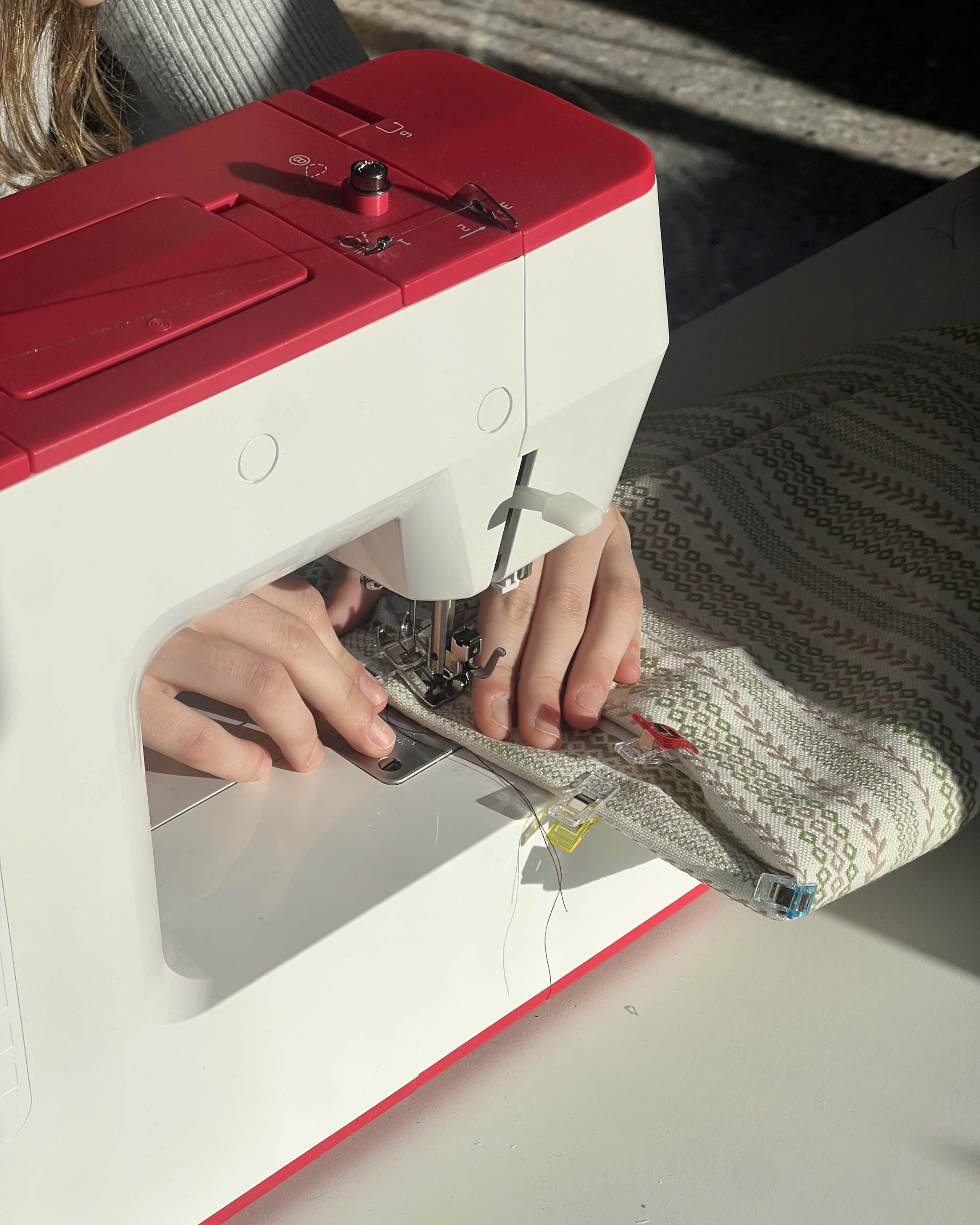 Manos cosiendo a máquina durante un taller de costura en Granollers