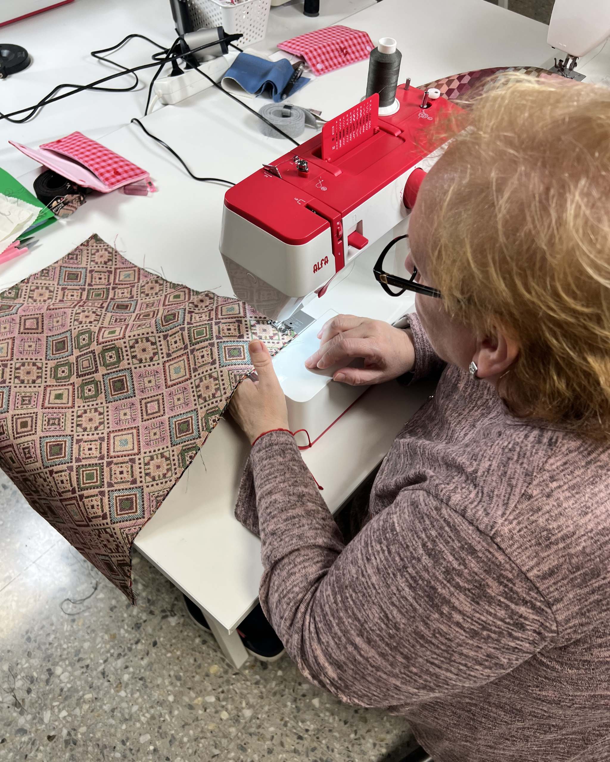 Participante aprendiendo a usar la máquina de coser