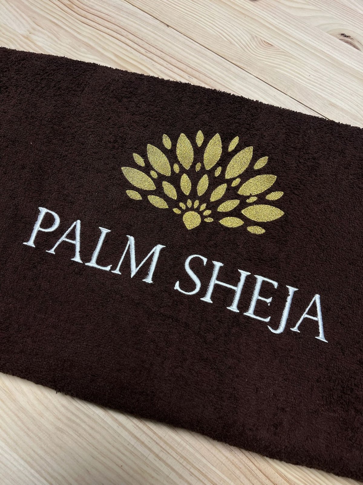 Toalla con logo bordado en hilo dorado para Palm Sheja